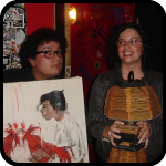 Man With Cockfighting Painting Woman With Popsicle Stick Lamp
