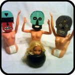 Three Ceramic Skulls About to Eat a Barbie Head Three Ceramic Skulls About to Eat a Barbie Head